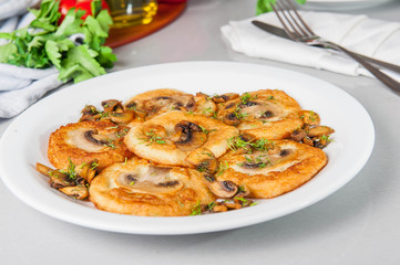 Potato pancakes with mushrooms on the white plate on the table with different bright ingredients, restaurant menu, Selective focus