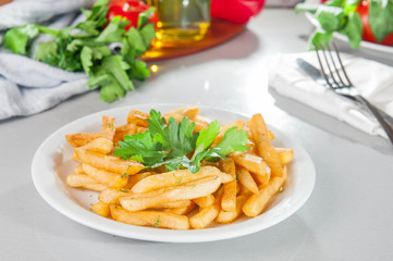 A Serving plate of french fries on the served table with fresh ingridients. Close- up. selective focus. Unhealthy food concept