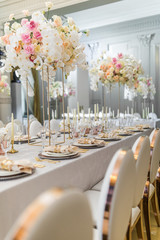 Chairs with round backs stand at dinner table with orchids