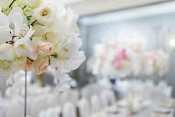 Close-up of beige roses in bouquet with white orchids