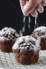 chocolate muffin, pouring powdered sugar
