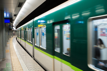 Interior of a Tokyo subway station and platform with subway commuters in Tokyo, Japan.
