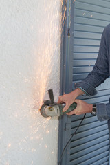 man makes do-it-yourself in his house grinder makes sparks