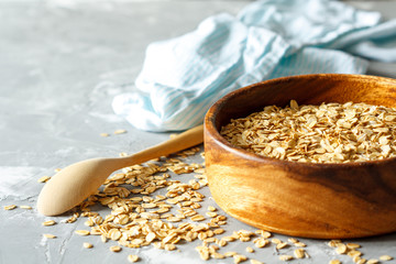 Raw oatmeal in a wooden bowl.