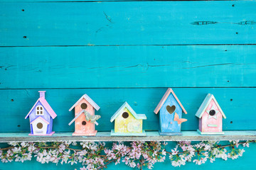 Row of colorful birdhouses with floral border