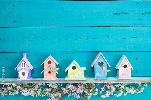 Row of colorful birdhouses with floral border