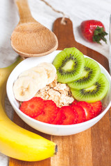 Cereal with fresh fruit on the table on a wooden board