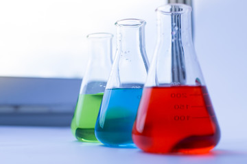 Flasks have colorful liquids, chemical substances, solutions and fren on the table in the laboratory.