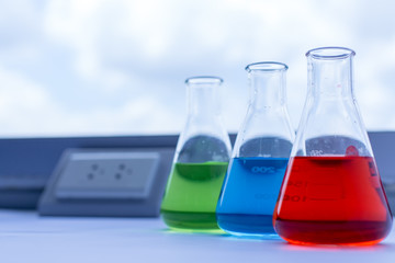 Flasks have colorful liquids, chemical substances, solutions and fren on the table in the laboratory.
