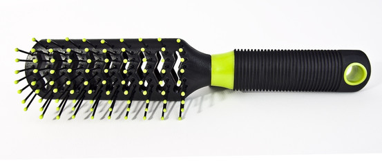 Fototapeta premium Isolated black hairbrush with bright green accents.