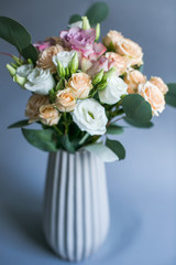 White tall porcelain vase with beige and pink roses