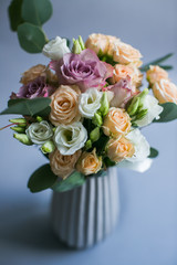 Bouquet of white, beige and violet roses put in porcelain vase