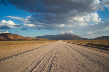 Scenic View of a Desert and Mountain Landscape with Clouds and Road near Solitaire, Namibia