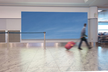 Airport traveler with blue sky sign