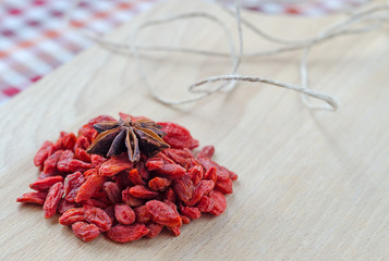 Goji berries and clove on a wooden Board.