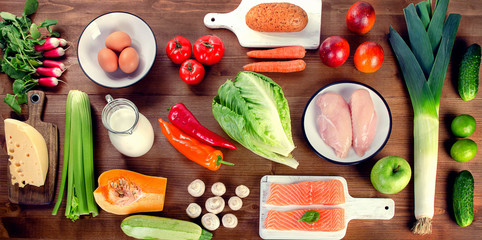 Vegetables, fruit, fish, milk and meat on wooden background. Balanced diet.