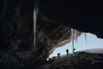Mountanineers exploring a cave with stalactites