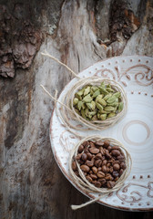 Coffee beans and green cardamom on aged wood