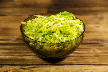 Savoy cabbage salad in glass bowl on wooden table