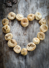 Dried figs in the form of heart on aged wood