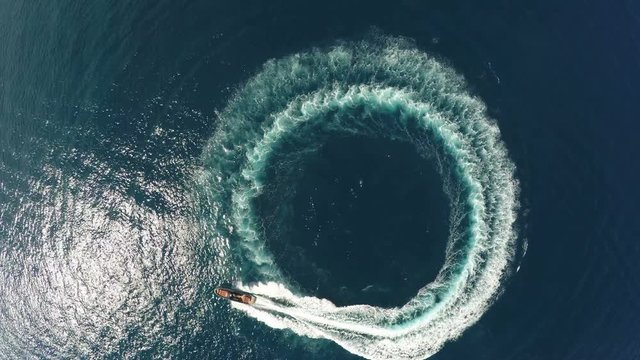 Perpendicular aerial view of a maxi rib designing a circle in the sea.