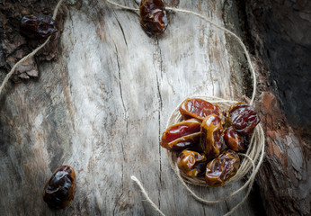Dried dates with twine on aged timber