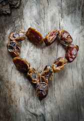 Dried dates in the form of heart on aged wood