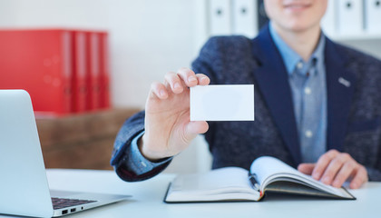 Businessman holding visit card. Man showing blank business card. Person in blue suit. Mock up...