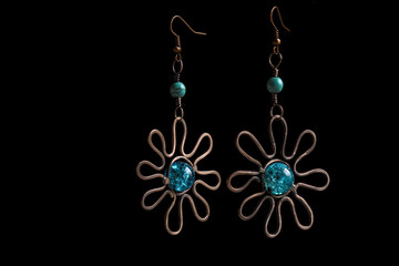 Copper earrings with blue turquoise on black background