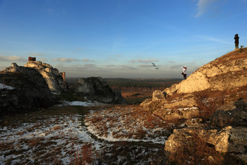 Turyści w górach obserwują ptaki przez lornetki, zimą.