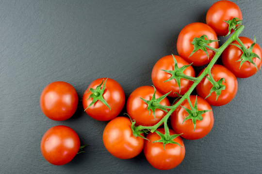 Tomaten - Rispentomaten auf einer Schieferplatte mit Textfreiraum