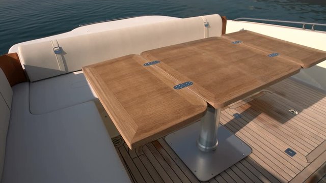 Small table and sofas on rear area of a fancy boat.