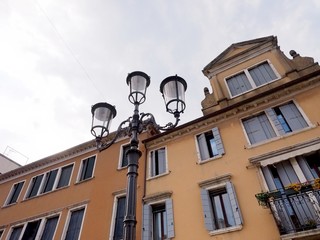 Fototapeta na wymiar Facade with many windows, and ancient street lamp, in Chioggia, Italy