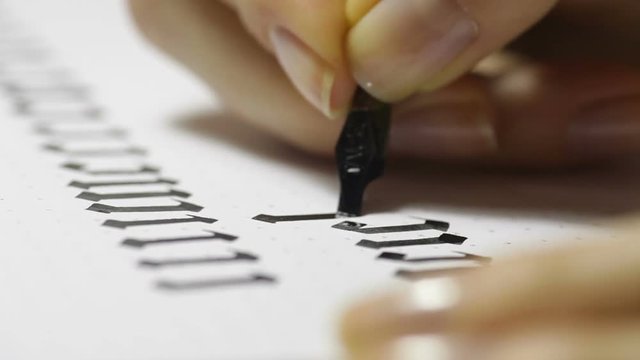 Woman writes pen with calligraphic letters