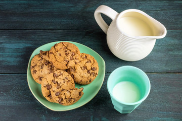 Chocolate chips cookies with glass and jar of milk