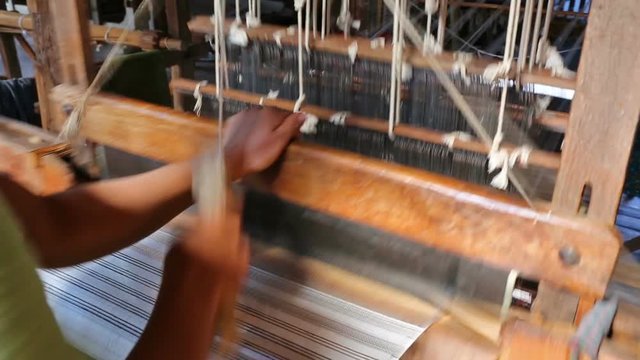 The local worker is weaving with handloom in the factory, Inle lake, Myanmar
