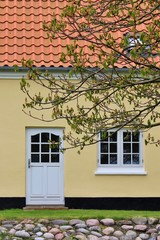 Traditional, danish architecture. Front of house with white door and windows. 