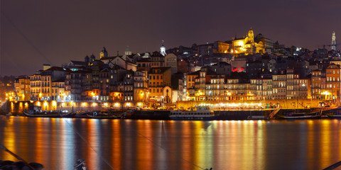 Fototapeta premium Ribeira and Old town of Porto with mirror reflections in the Douro River during evening blue hour, Portugal, Portugal.