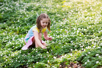 Child in spring park with flowers