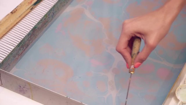 An artist using ebru technique making picture slow motion