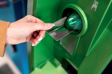 Obraz premium the girl withdraws money from the ATM