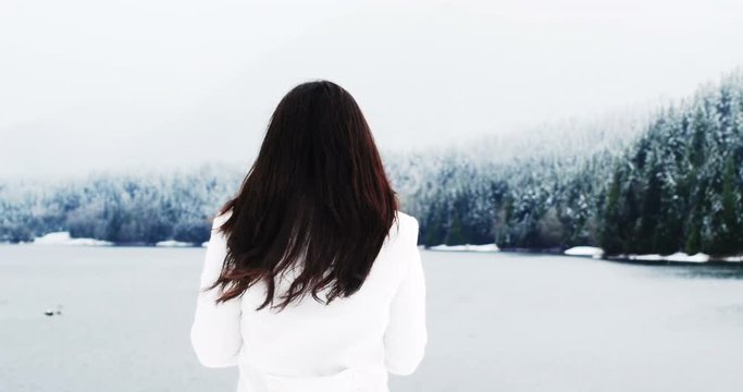 Rear view of woman standing in snow covered landscape