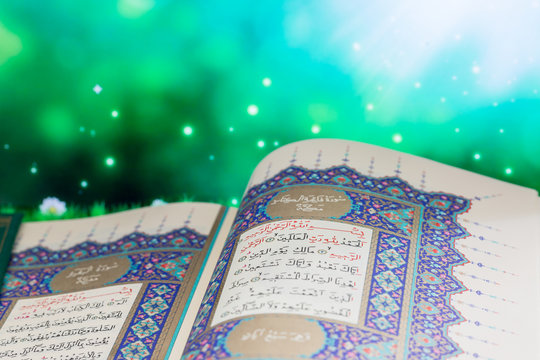 Opening pages of holy book Qur'an with green lights background