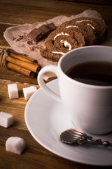 Sweet roll and coffee on a wooden background.