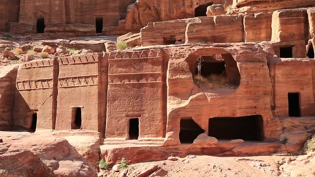 Crenellated rupestrian rock cut tombs along the Street of Facades in ancient city of Petra, originally known to Nabataeans as Raqmu - historical and archaeological city in Hashemite Kingdom of Jordan