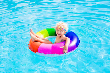 Child with toy ring in swimming pool