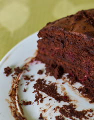 Homemade truffle-cranberry cake chocolate cream cut into pieces on table