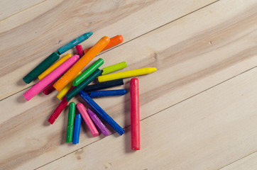 Obraz premium Wax crayons on white sheet, wooden background