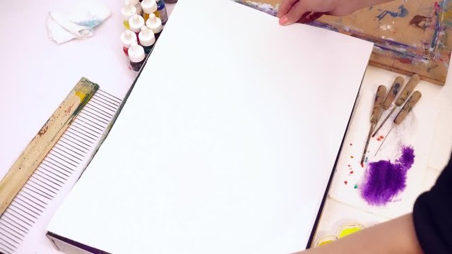 Woman artist transfering the ebru picture to the paper