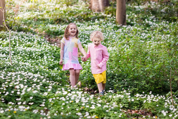 Fototapeta premium Children in spring park with flowers